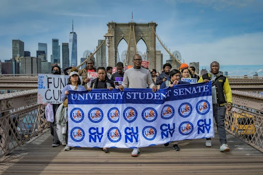 Marching over the bridge with Fund CUNY signs