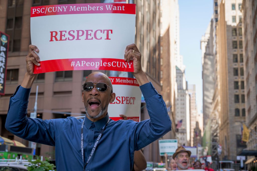 Member holding "RESPECT" sign at rally