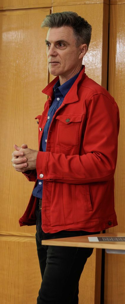 PSC member wearing red jacket during town hall