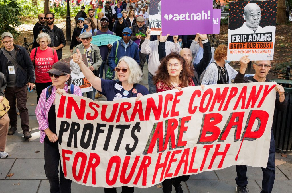 Reitrees march with banner: Insurance Company Profits are BAD For Our Health!"