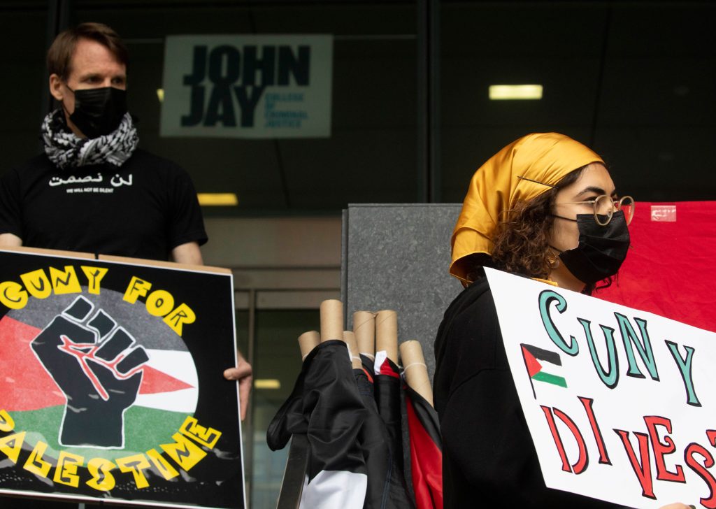 Protestors hold signs reading "CUNY for Palestine" and "CUNY Divest"