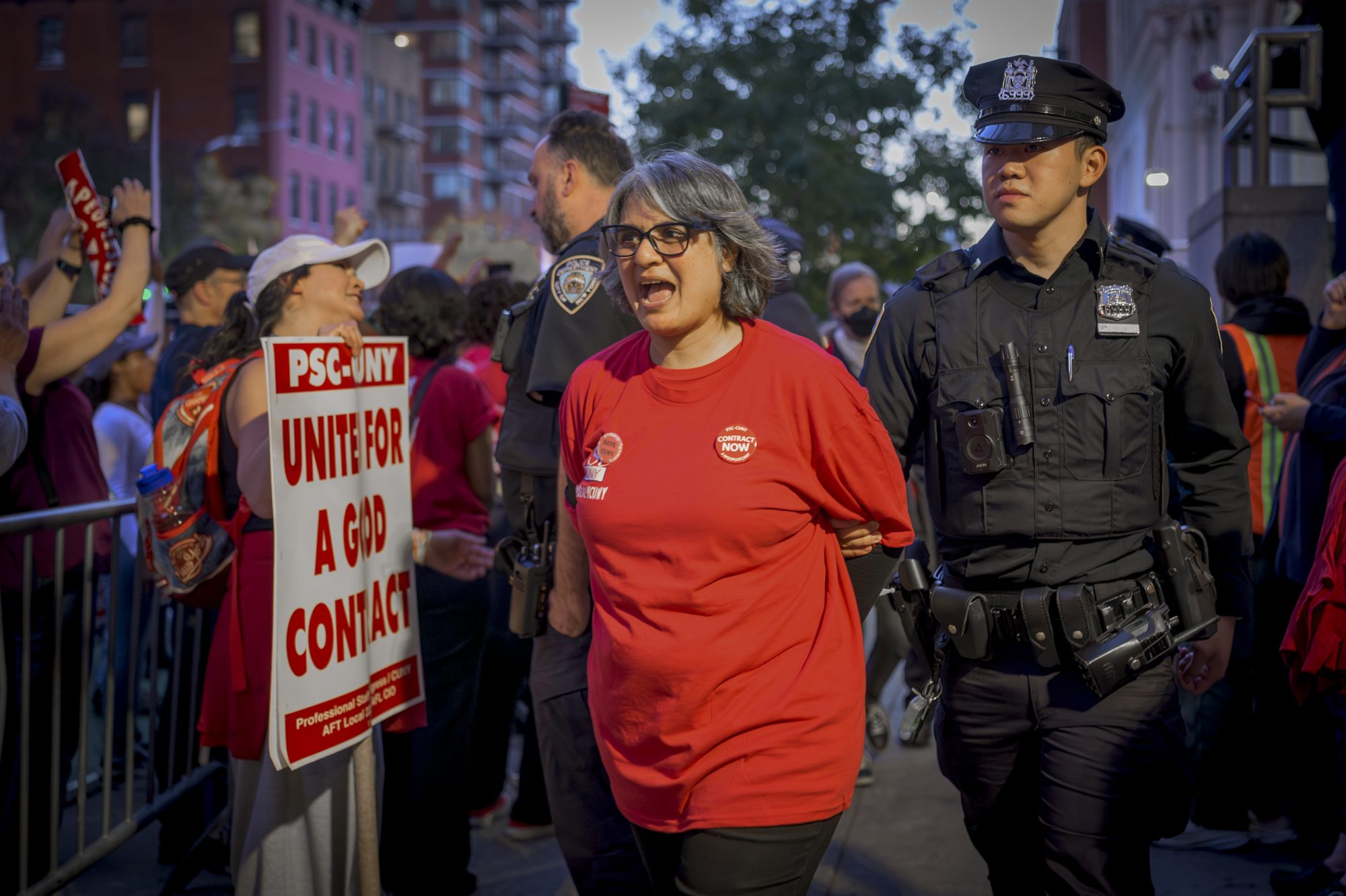 More than 30 faculty and staff of the City University of New York were arrested on October 21, 2024 during a union protest blocking the 10th Avenue entrance to CUNY’s John Jay College during a hearing of the Board of Trustees and refused to move demanding management to make an offer that would ensure real raises for workers and a quality college education for students. Hundreds more CUNY faculty and staff, students, and labor allies chanted “Real Raises! Job Security! Contract Now!” during the blockade. (Photo by Erik McGregor)